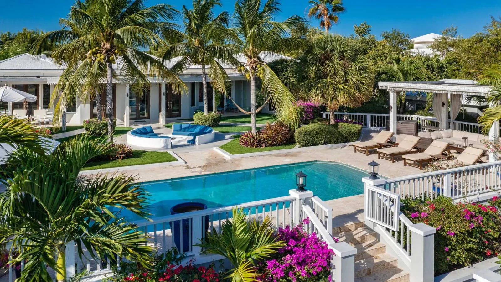 Aerial view over the villa pool, palms and pavilions in Providenciales.